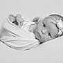 newborn, baby, infant, swaddled, black_and_white, portrait, headband, flower, soft_texture, peaceful, resting, curious_gaze, wrapped, cute, small_feet, closeup, monochrome, baby_face, lying_down, blanket