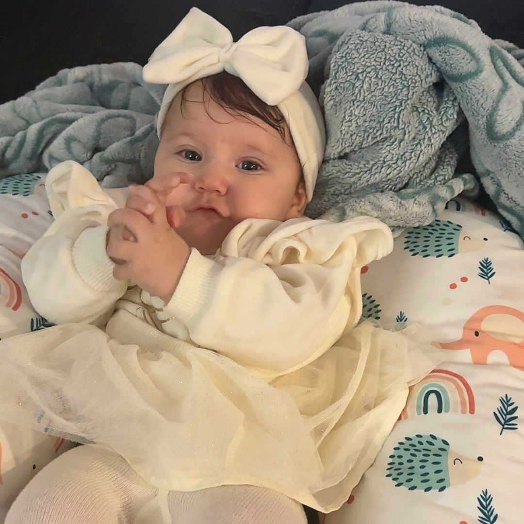 Lovelynn is registered to the contest to win money with this photo: baby, bed, blanket, bodypart, bonnet, cap, clothing, couch, cushion, face, finger, furniture, hat, head, homedecor, newborn, person, photography, portrait, quilt