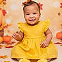 autumn, baby, child, colorful, cute, decor, fall_leaves, festive, happy, headband, indoor, infant, person, portrait, pumpkins, seasonal, sitting, smiling, studio_photo, yellow_dress