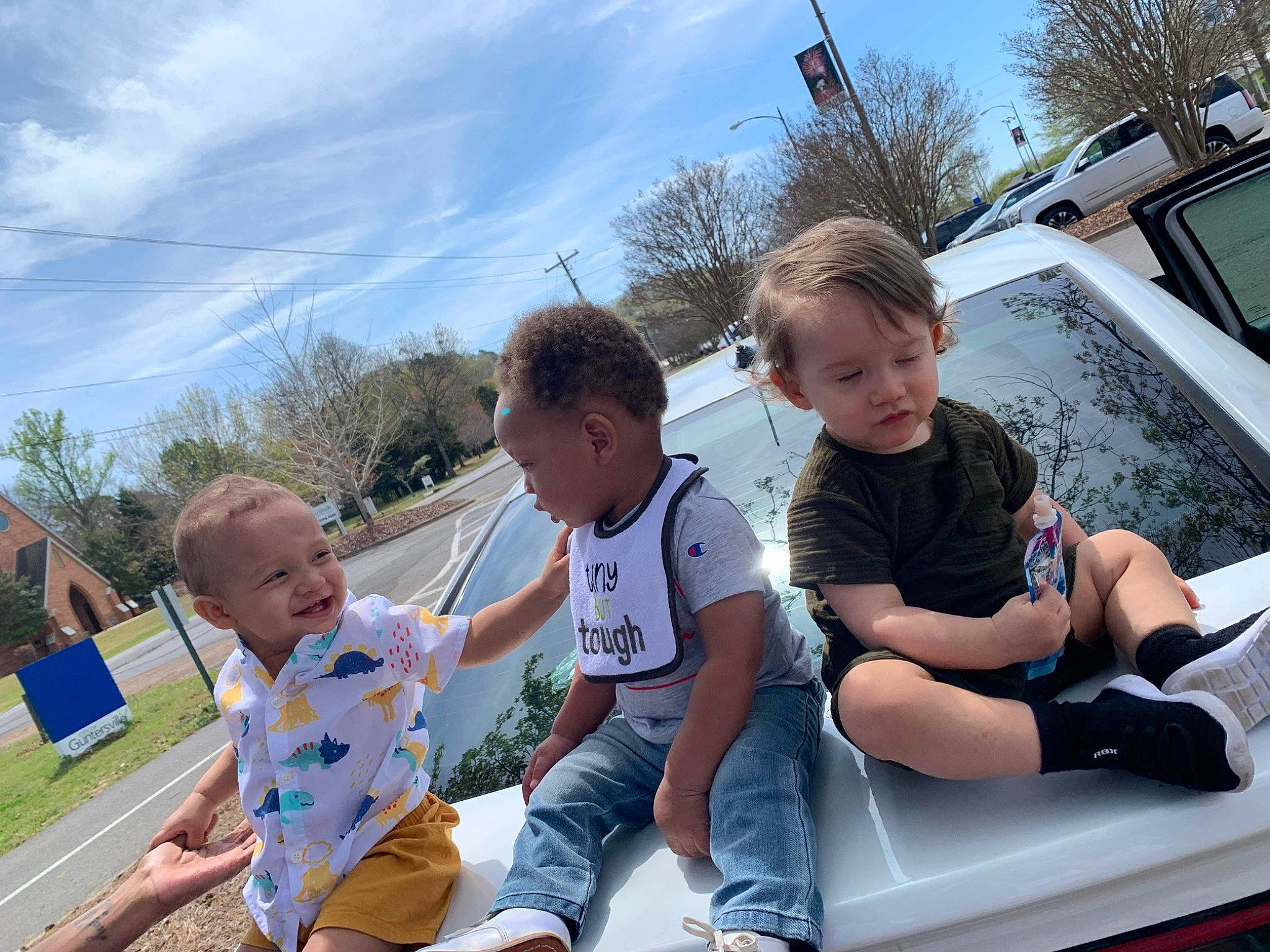 Armoni is registered to the contest to win money with this photo: automotive_exterior, child, cloud, event, fun, grass, happy, hood, leisure, motor_vehicle, person, recreation, shorts, sitting, sky, sneakers, summer, t_shirt, toddler, tree