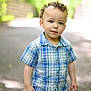 Jay is registered to the contest to win money with this photo: boy, casual_clothing, child, curly_hair, cute, daylight, greenery, innocent, nature, outdoor, pants, pathway, person, plaid_shirt, portrait, short_sleeves, standing, sunlight, toddler, young