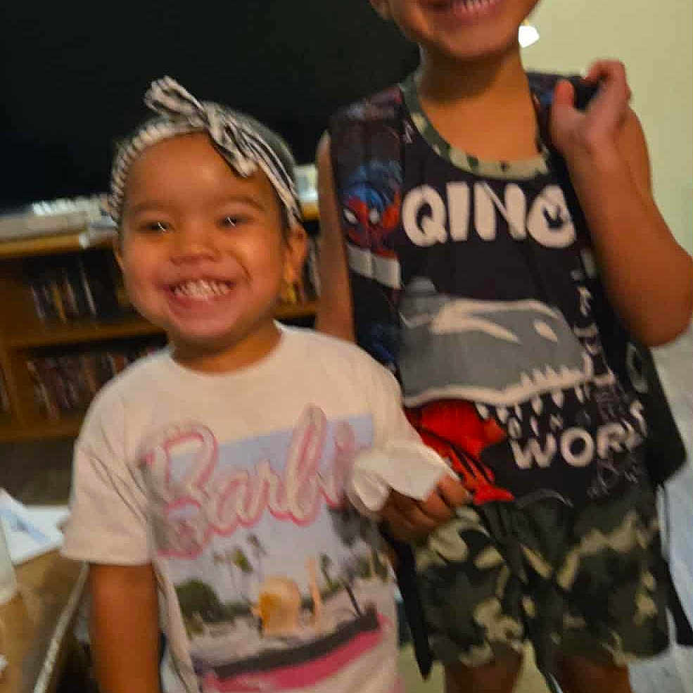 Hennessy joined the competition — help win amazing prizes! blur, boy, camo, carpet, child, clothing, furniture, girl, happy, headband, indoor, living_room, person, shoes, shorts, smiling, socks, standing, television, tshirt