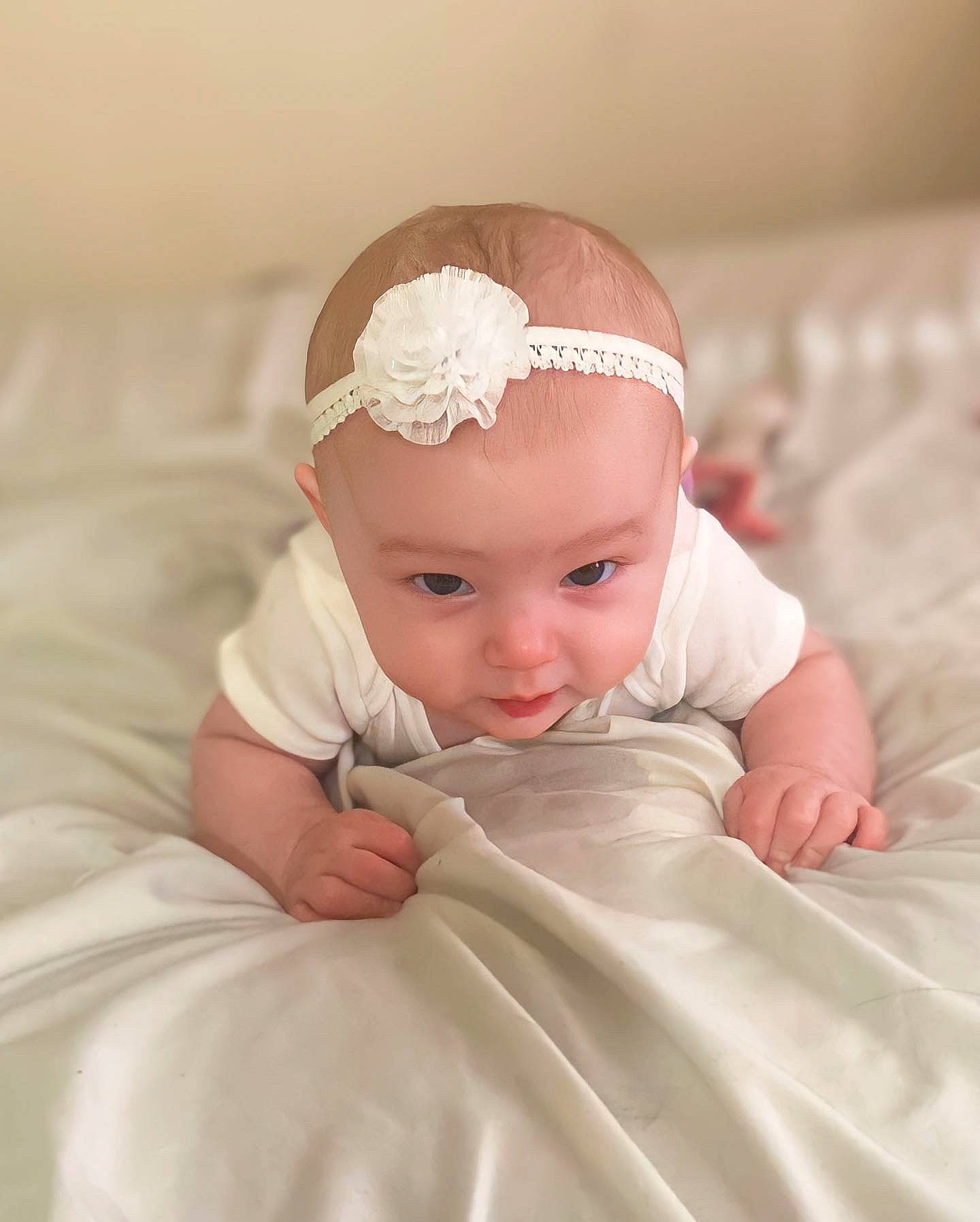 Alora is registered to the contest to win money with this photo: baby, baby_toddler_clothing, bridal_accessory, cap, child, dress, ear, embellishment, eye, eyebrow, flash_photography, hand, happy, head, headband, headpiece, headwear, jewellery, person, skin