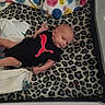 Richard joined the competition — help win amazing prizes! baby, infant, onesie, puma_logo, leopard_print, blanket, playpen, smiley_faces, cloth, fabric, cute, newborn, sleeping_area, pattern, soft, indoors, child, resting, face, small