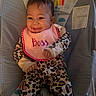 baby, smiling, infant, bib, leopard_print, onesie, baby_seat, rainbow, monkey, colorful, happy, cute, child, indoors, face, clothing, portrait, seat, cheerful, joy