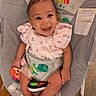 baby, smiling, infant, child, toy, seat, baby_rocker, clothing, cute, happy, face, skin, hand, foot, indoor, colorful, fabric, pattern, playful, portrait