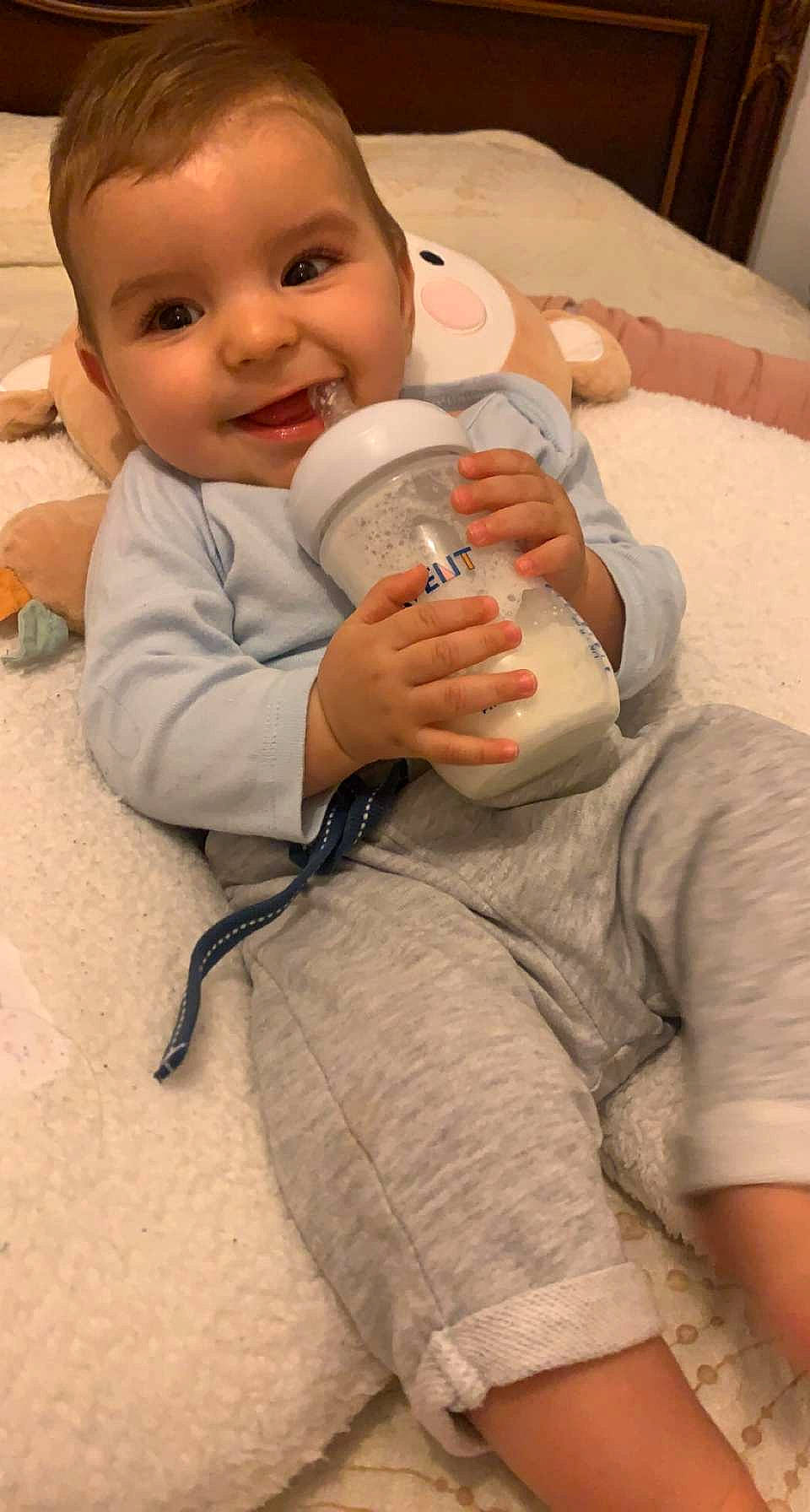 Imrân a rejoint le concours — aidez-le/la à gagner de superbes lots ! arm, baby, baby_bottle, bottle, cheek, comfort, drinkware, finger, gesture, happy, head, human_body, joy, mouth, nail, nose, person, plastic_bottle, skin, smile