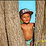 child, boy, tree, nature, outdoor, cap, smiling, sunlight, blue_sky, summer, grass, playful, portrait, bare_chest, happy, young, daytime, casual, cute, innocent