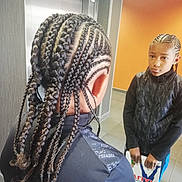 Ylann a rejoint le concours — aidez-le/la à gagner de superbes lots ! black_jacket, blue_pants, book, braids, child, clothing, floor_tiles, hair_style, hairstyle, holding_object, indoor, mirror, modern_interior, orange_wall, person, portrait, reflection, serious_expression, standing, young_person