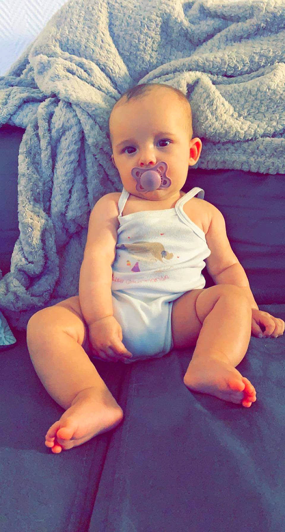 Anaë participe au concours pour gagner de l'argent avec cette photo : baby, baby_toddler_clothing, cheek, comfort, eye, face, finger, happy, head, human_body, iris, leg, mouth, neck, person, pink, skin, sleeve, stomach, thigh