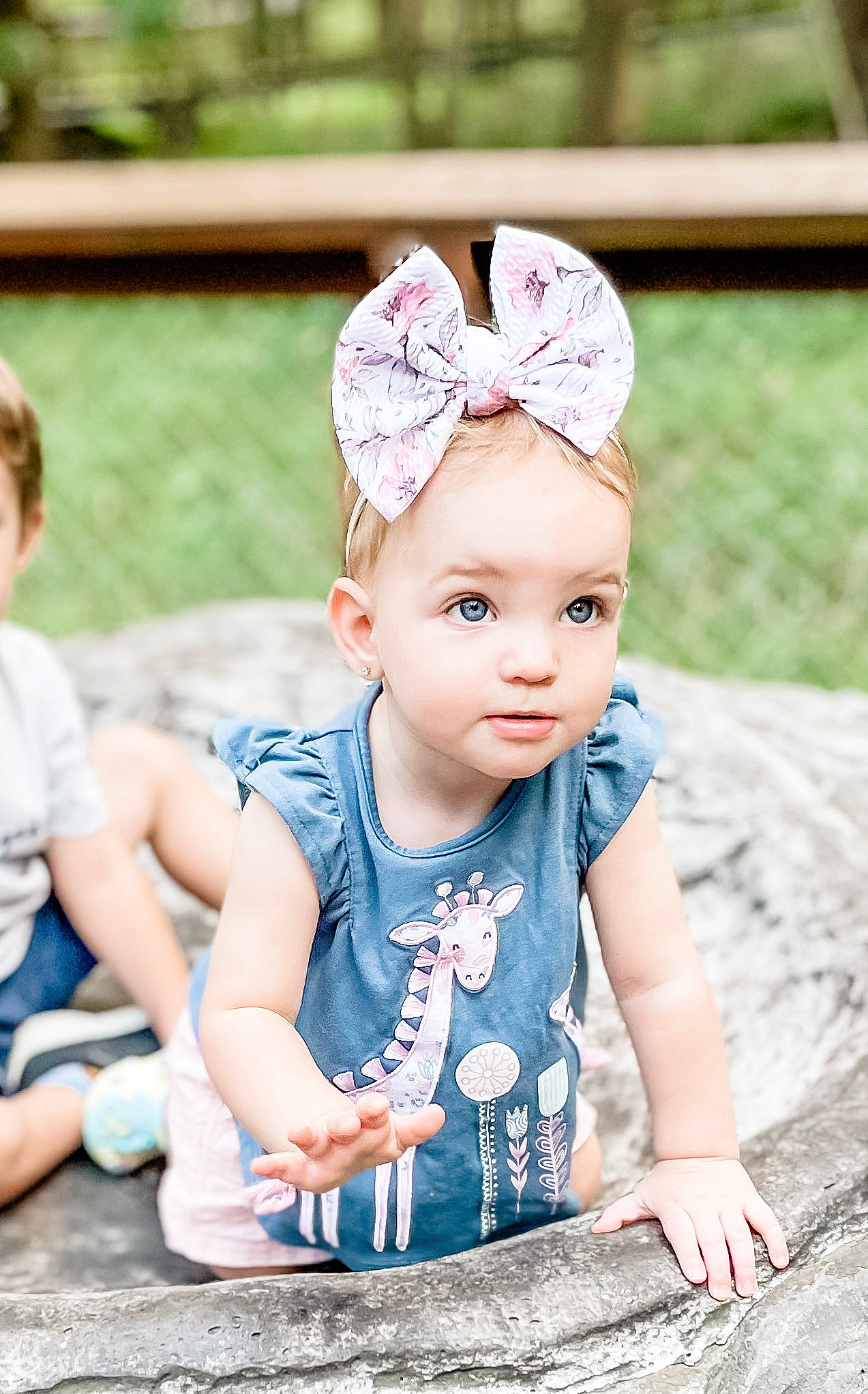 Finley is registered to the contest to win money with this photo: baby, baby_toddler_clothing, cap, child, costume_hat, fashion_accessory, fun, grass, happy, headband, headgear, headpiece, jewellery, necklace, pattern, people_in_nature, person, photograph, pink, sitting