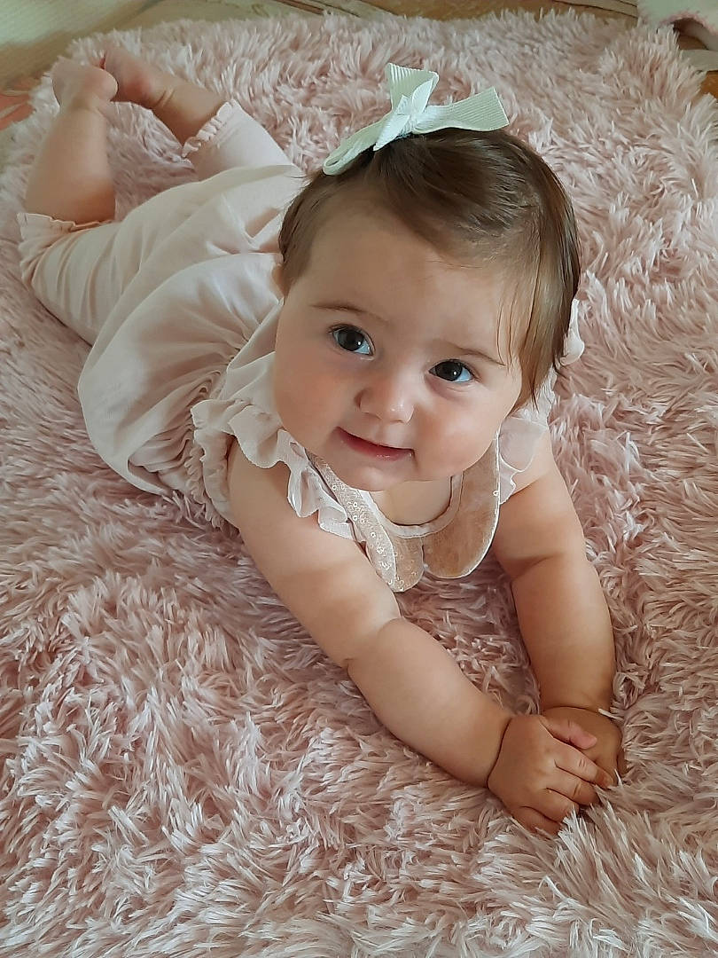 Nélia a rejoint le concours — aidez-le/la à gagner de superbes lots ! baby, baby_toddler_clothing, child, comfort, eye, flash_photography, flooring, grass, hair_accessory, happy, headgear, iris, linens, pattern, person, product, skin, sleeve, smile, textile