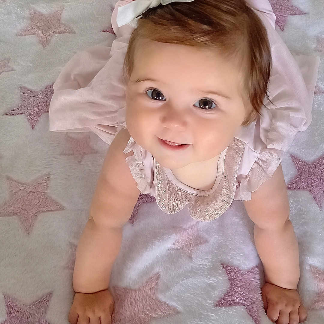 Nélia a rejoint le concours — aidez-le/la à gagner de superbes lots ! arm, baby, baby_toddler_clothing, cheek, dress, eye, eyebrow, finger, hair, hand, happy, head, iris, lip, pink, skin, sleeve, smile, textile, white