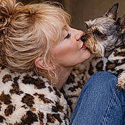 Fela is registered to the contest to win money with this photo: affection, animal, blonde_hair, bun, casual, close_up, coat, cute, dog, friendship, fur, indoor, jeans, kiss, leopard_print, love, pet, portrait, red_collar, woman