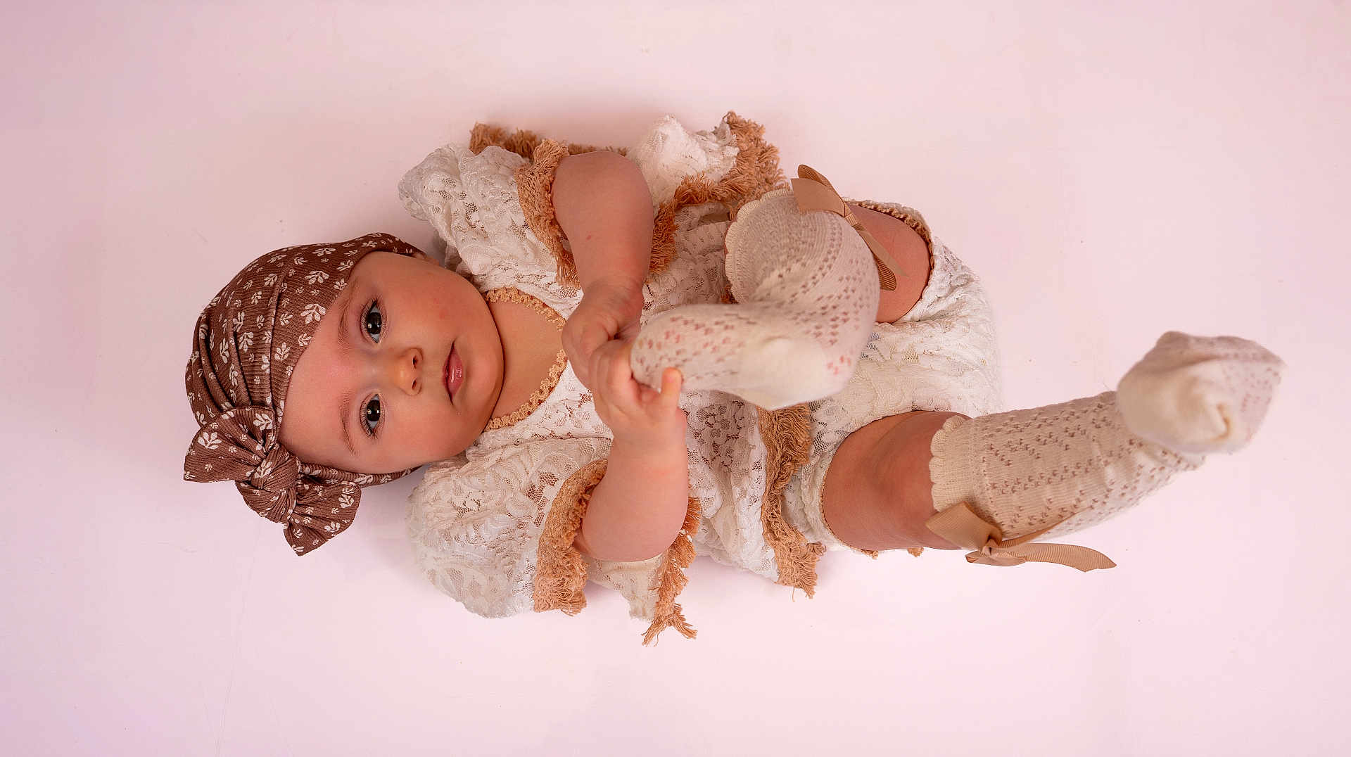 Hortense a rejoint le concours — aidez-le/la à gagner de superbes lots ! baby, infant, child, headscarf, bow, lace_dress, socks, knee_socks, pink_background, studio, portrait, lying_down, hand, foot, eyes, cheeks, soft_texture, cute, accessory, ribbon