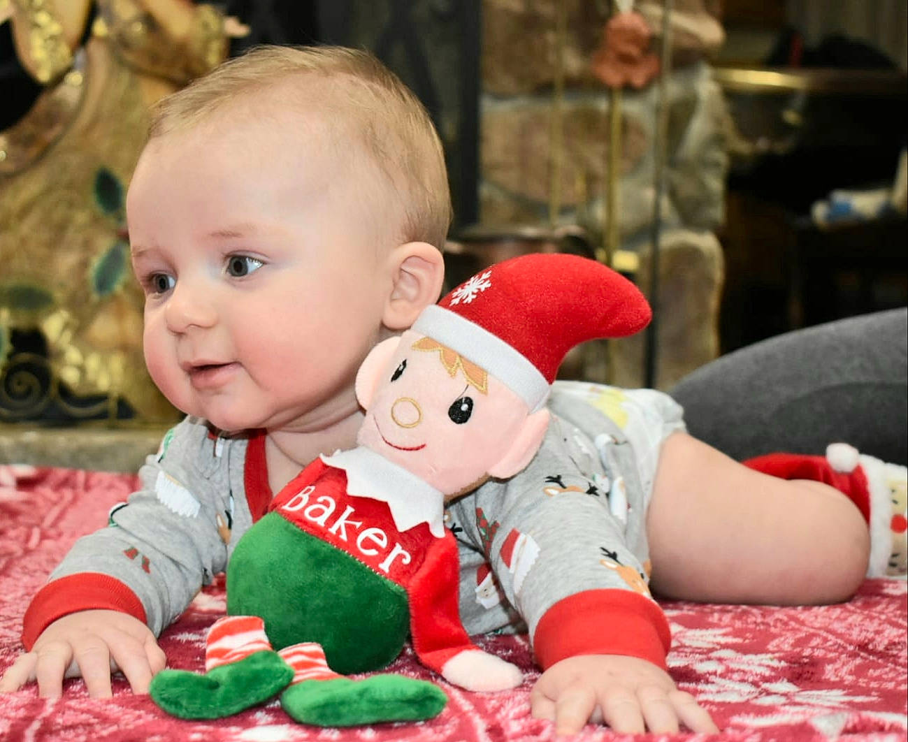 Baker is registered to the contest to win money with this photo: baby, child, christmas, christmas_eve, person, play, sitting, stuffed_toy, toddler, toy, tummy_time