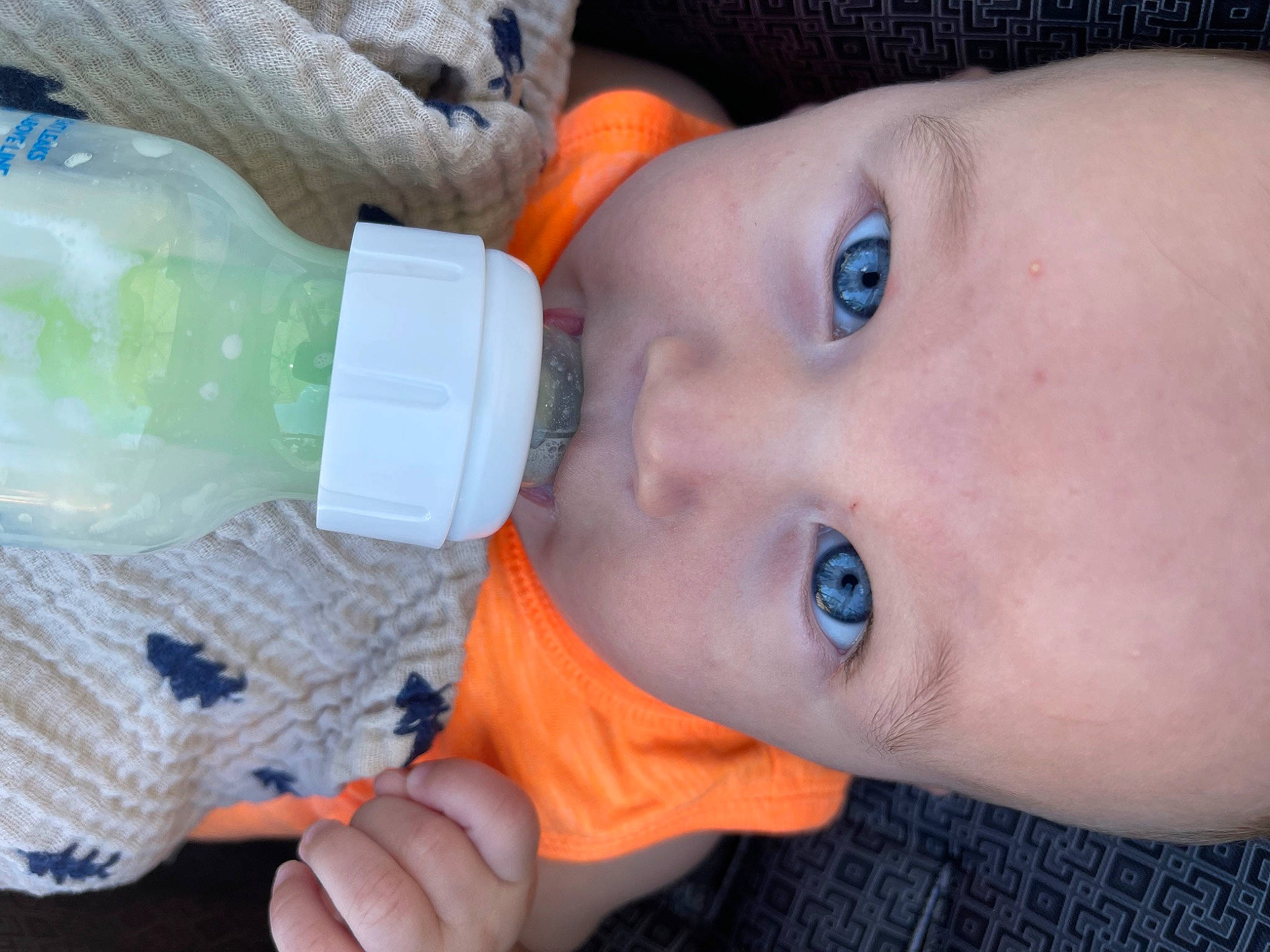 Colton joined the competition — help win amazing prizes! baby, bottle, cheek, drinkware, eyelash, face, facial_expression, finger, gesture, green, lip, mouth, nail, nose, organ, person, plastic_bottle, skin, toddler, water