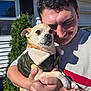 Hercules is registered to the contest to win money with this photo: person, dog, pet, smiling, holding, jacket, outdoor, sunlight, house, window, greenery, tree, closeup, portrait, happy, casual_clothing, skin, hand, fur, face