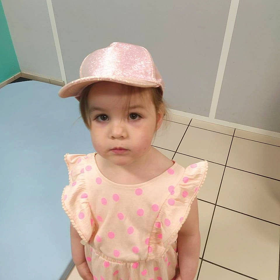Priscillia a rejoint le concours — aidez-le/la à gagner de superbes lots ! active_tank, baby, baby_toddler_clothing, cap, cheek, chest, child, eyelash, face, fashion_accessory, flooring, happy, hat, headwear, magenta, pattern, person, pink, room, sleeve