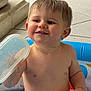 toddler, child, smiling, playing, pool, water, plastic_container, yellow_cup, indoor, floor_tiles, stone_pillar, bare_chest, happy, cute, young_child, short_hair, person, infant, fun, summer