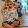 toddler, child, floor, kitchen, shirt, shorts, barefoot, indoor, appliance, oven, door, window, wooden_floor, plant, relaxed, curious, home, casual, young_child, portrait