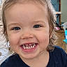 child, toddler, girl, smiling, grinning, portrait, close_up, face, teeth, bow, hair, blue_shirt, indoors, home, background, happy, cute, looking_at_camera, young_child, photography