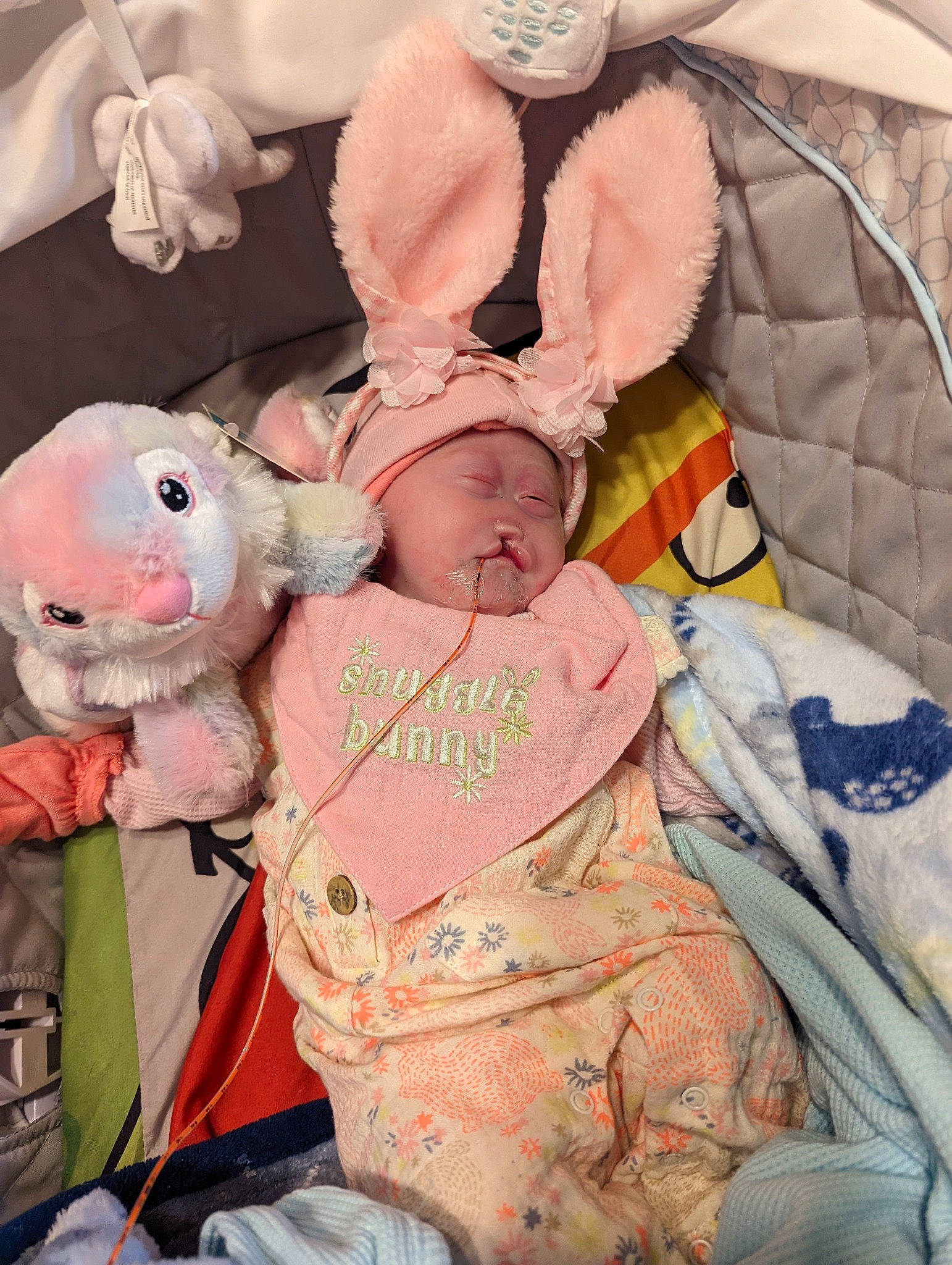 Hazel is registered to the contest to win money with this photo: baby, baby_products, baby_sleeping, baby_toddler_clothing, cheek, child, comfort, event, happy, headwear, infant_bed, linens, peach, person, pink, plush, product, skin, stuffed_toy, teddy_bear
