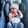 baby, sleeping, car_seat, knit_hat, pom_poms, blue_pants, white_shirt, infant, child, cute, cozy, soft_fabric, padded, indoor, peaceful, hands, face, headwear, child_boy, resting
