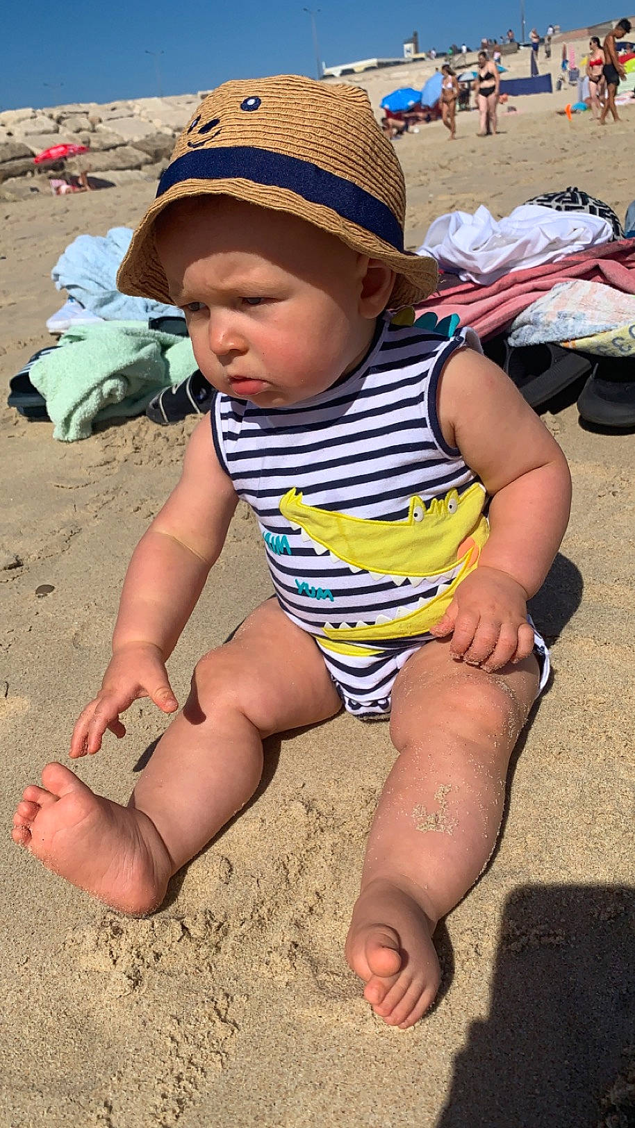 Lissandro a rejoint le concours — aidez-le/la à gagner de superbes lots ! baby, barefoot, beach, child, foot, fun, hat, headwear, human_leg, leisure, people_on_beach, person, photograph, sand, shorts, sitting, skin, snapshot, summer, sun_hat