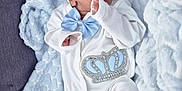 Oliver-John is registered to the contest to win money with this photo: adorable, baby, blue_bow, child, clothing, cozy, crown_design, cute, footwear, hat, indoors, infant, newborn, peaceful, portrait, resting, sleep, sleeping, soft_blanket, white_outfit