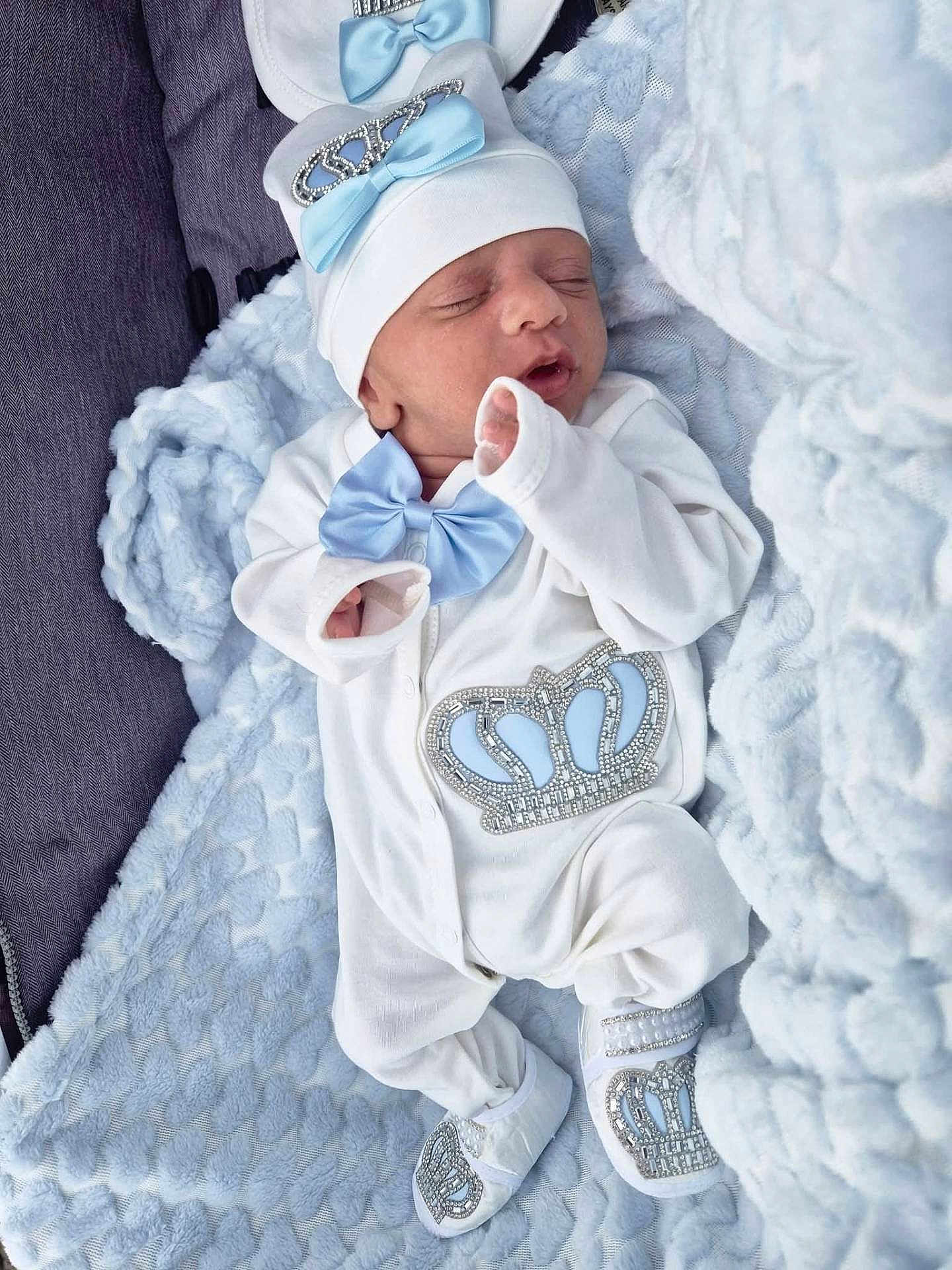 Oliver-John is registered to the contest to win money with this photo: adorable, baby, blue_bow, child, clothing, cozy, crown_design, cute, footwear, hat, indoors, infant, newborn, peaceful, portrait, resting, sleep, sleeping, soft_blanket, white_outfit