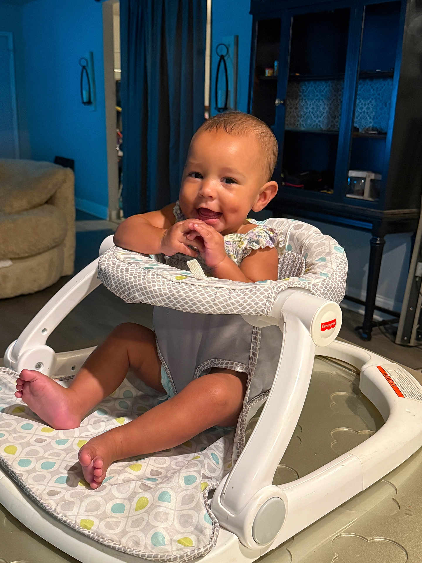 Jayella is registered to the contest to win money with this photo: baby, walker, smiling, indoor, child, furniture, living_room, seat, footwear, person, cute, happy, infant, toy, floor, home, small_child, legs, hands, expression