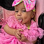Jayella is registered to the contest to win money with this photo: baby, child, pink, bow, tongue, car_seat, ruffles, cute, playful, infant, clothing, fabric, hand, expression, portrait, closeup, seat, headwear, person, smile