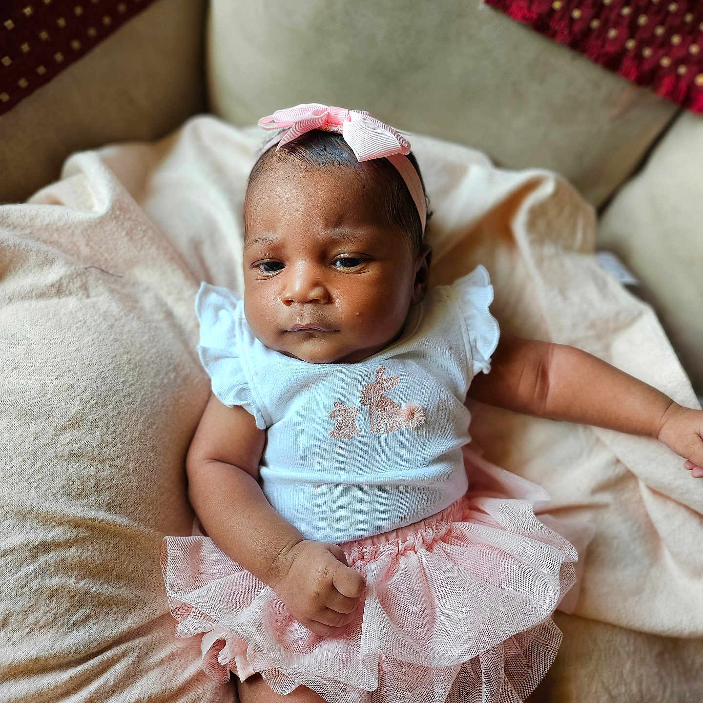 Londyn is registered to the contest to win money with this photo: baby, bed, bonnet, clothing, couch, cushion, dress, face, furniture, happy, hat, head, homedecor, newborn, people, person, photography, portrait, sitting, smile