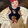 Reamonnee is registered to the contest to win money with this photo: baby, child, infant, headband, red_bow, smiling, sitting, blanket, wooden_sign, eight_months, clothing, cute, indoors, face, portrait, happy, young_child, seated, soft_background, playful