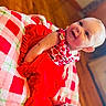 baby, child, smiling, red_clothing, heart_pattern, blanket, checkered, indoor, floor, happy, cute, infant, portrait, sitting, skin, foot, head, face, person, cozy