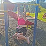 child, playground, slide, smiling, outdoor, grass, trees, sunlight, play, fun, casual_clothing, barefoot, happy, park, summer, recreation, exercise, friends, people, daytime