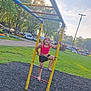 child, playground, climbing, ladder, smiling, barefoot, outdoor, grass, trees, sunlight, park, vehicle, casual_clothing, happy, summer, recreation, play, fun, daytime, nature