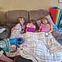 blanket, casual, child, children, couch, cozy, furniture, happy, home, indoor, living_room, plaid, playing, relaxed, seated, smartphone, smiling, tablet, technology, three_people