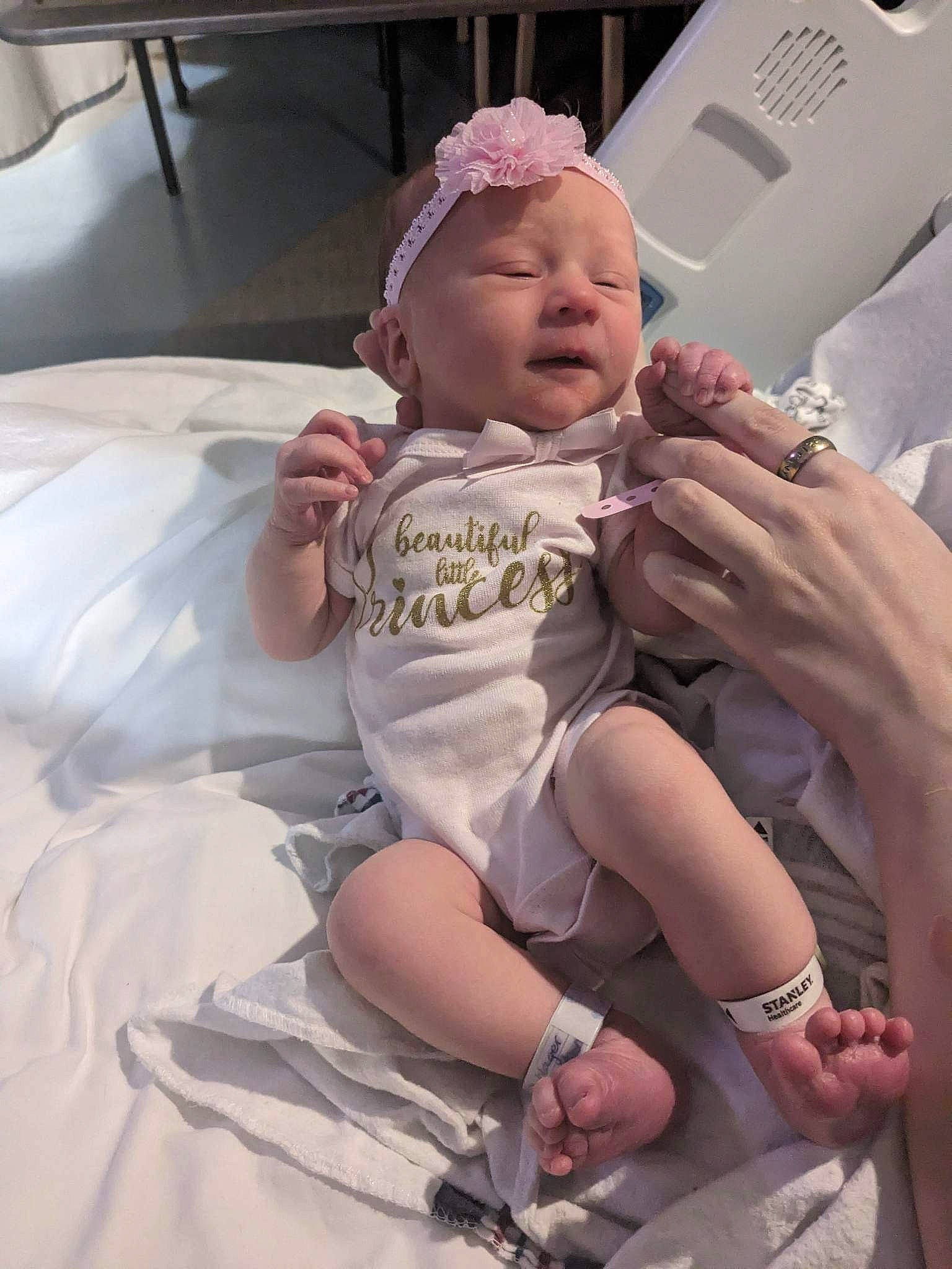 Caroline is registered to the contest to win money with this photo: baby, baby_products, baby_toddler_clothing, child, comfort, dress, event, foot, fun, gesture, hand, happy, hat, headwear, nail, person, pink, skin, thigh, thumb