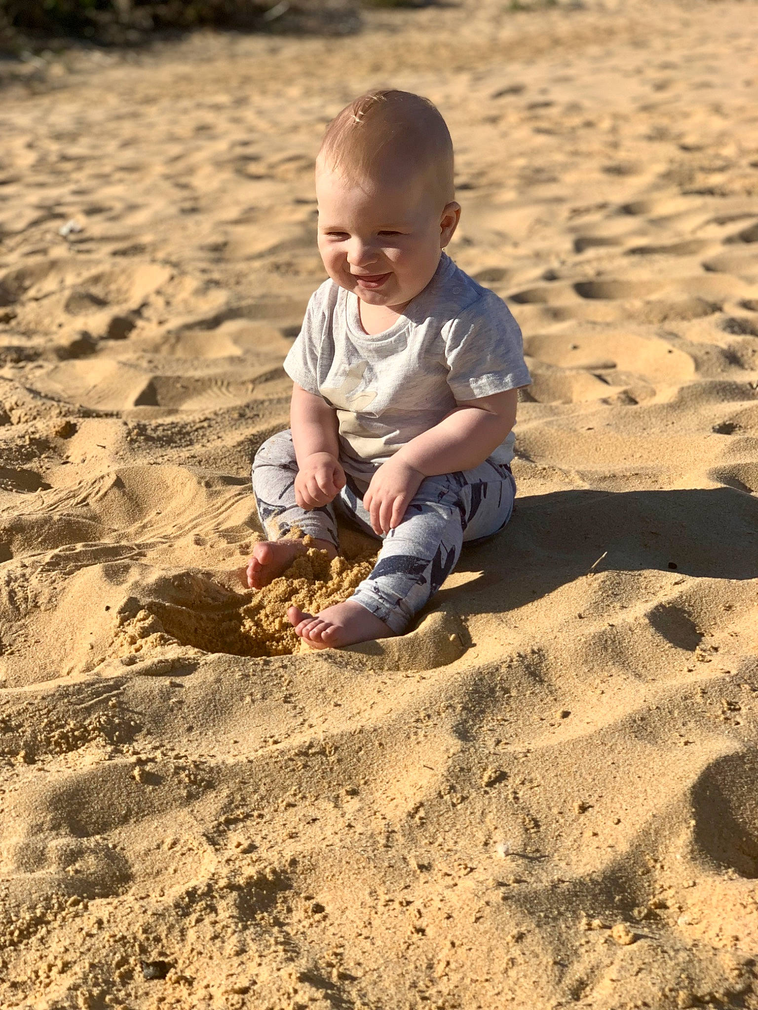 Dean joined the competition — help win amazing prizes! aeolian_landform, baby, baby_toddler_clothing, beach, child, footprint, fun, happy, landscape, ocean, people_in_nature, people_on_beach, person, play, sand, shadow, singing_sand, sitting, soil, toddler