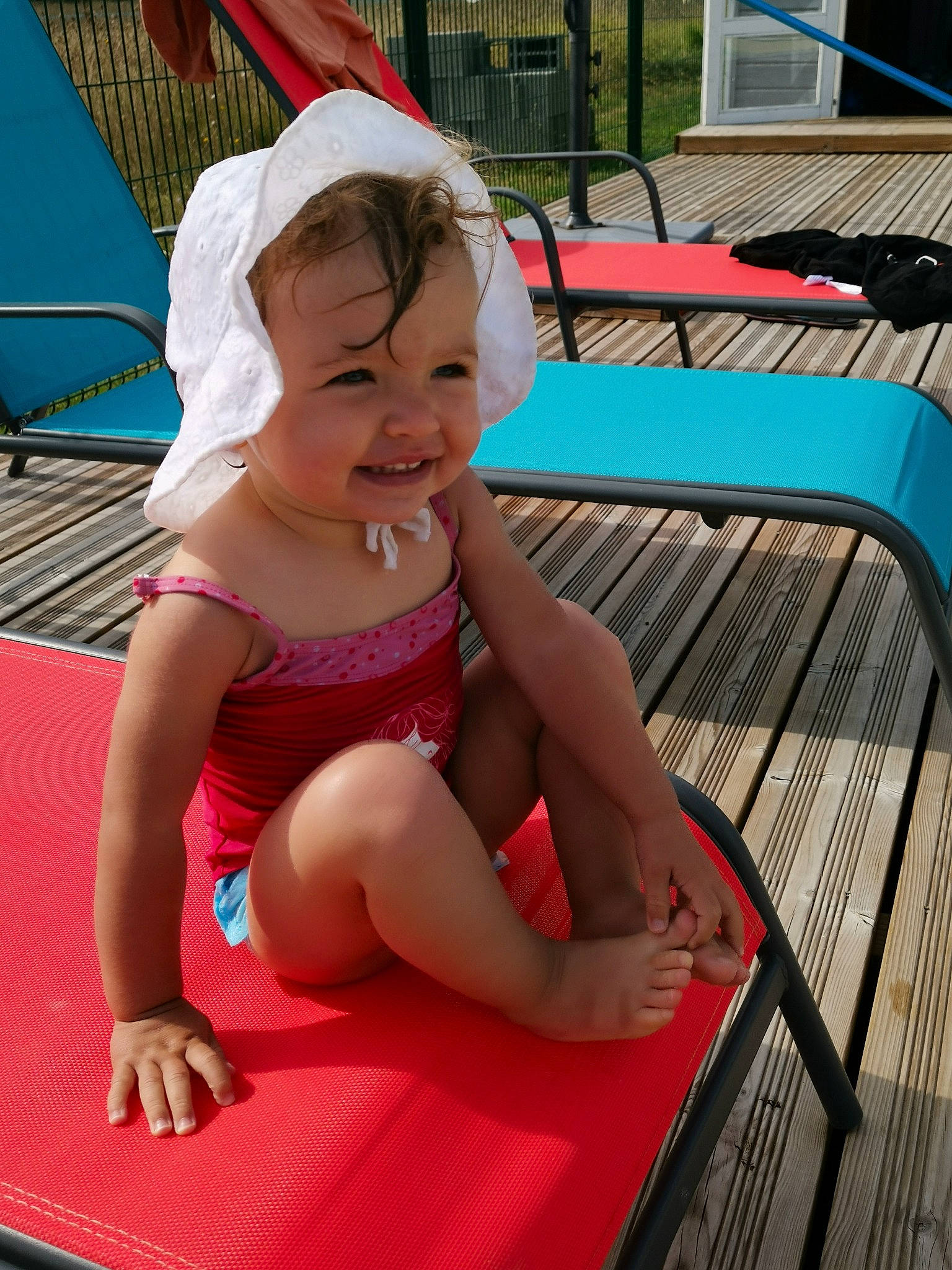 Lyana participe au concours pour gagner de l'argent avec cette photo : baby_toddler_clothing, barefoot, child, foot, fun, happy, hat, headwear, human_leg, joy, lap, leg, leisure, outdoor_furniture, person, recreation, sitting, skin, smile, swimming_pool