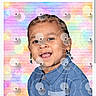 Shaun is registered to the contest to win money with this photo: child, toddler, smiling, portrait, braided_hair, earrings, blue_shirt, colorful_background, pastel_colors, brick_wall, happy, cute, person, studio_photo, indoors, fashion, young, joyful, head_and_shoulders, posing