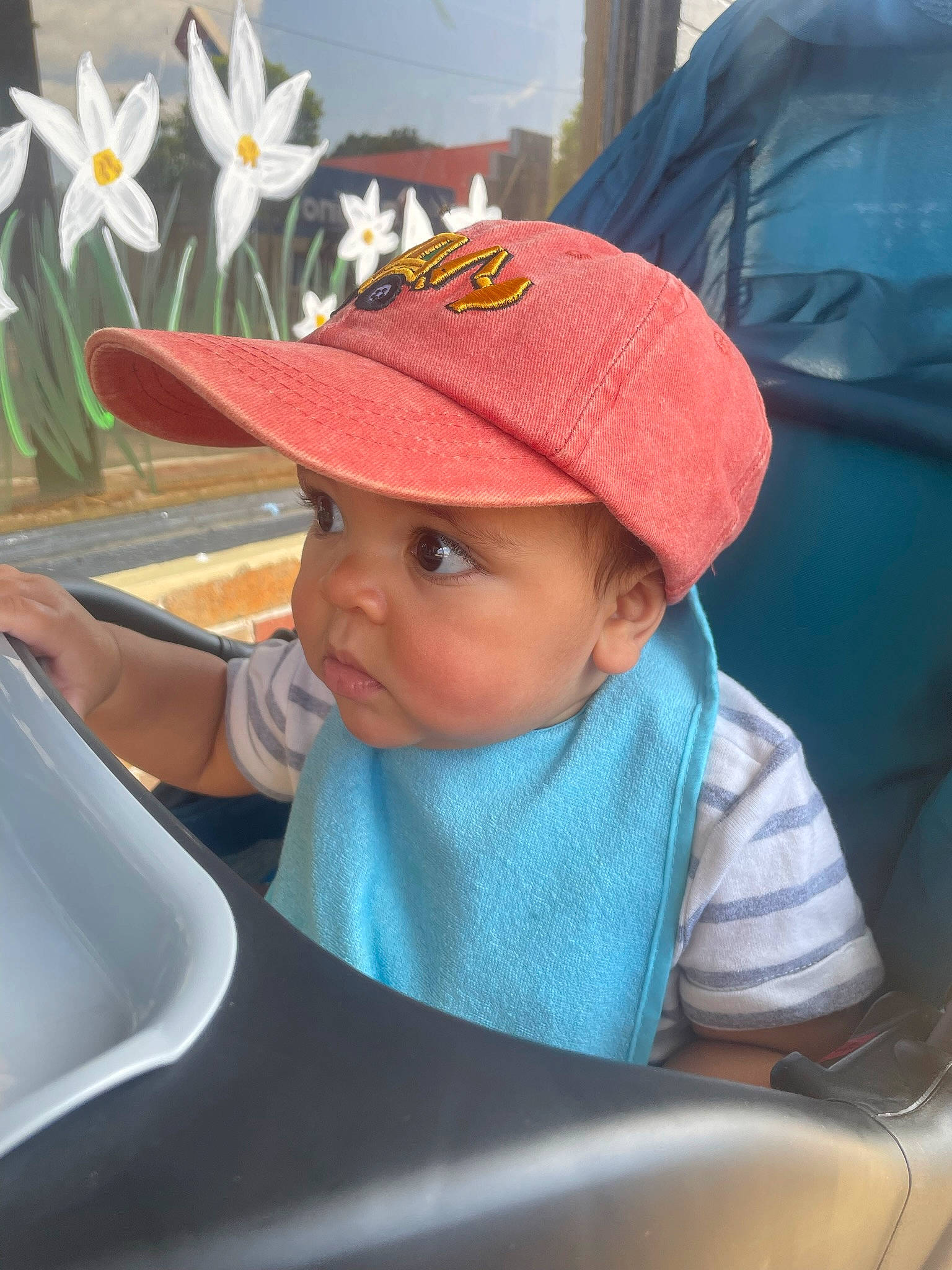 Karson is registered to the contest to win money with this photo: baby, baby_carriage, baby_products, baby_toddler_clothing, baseball_cap, cap, child, electric_blue, fashion_accessory, flower, fun, happy, hat, headwear, person, petal, plant, product, sitting, toddler