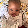 Mulahn joined the competition — help win amazing prizes! baby, face, tongue, blanket, smile, infant, cute, eyes, white_clothing, soft, cozy, wrapped, happy, child, person, indoors, fabric, colorful, playful, closeup