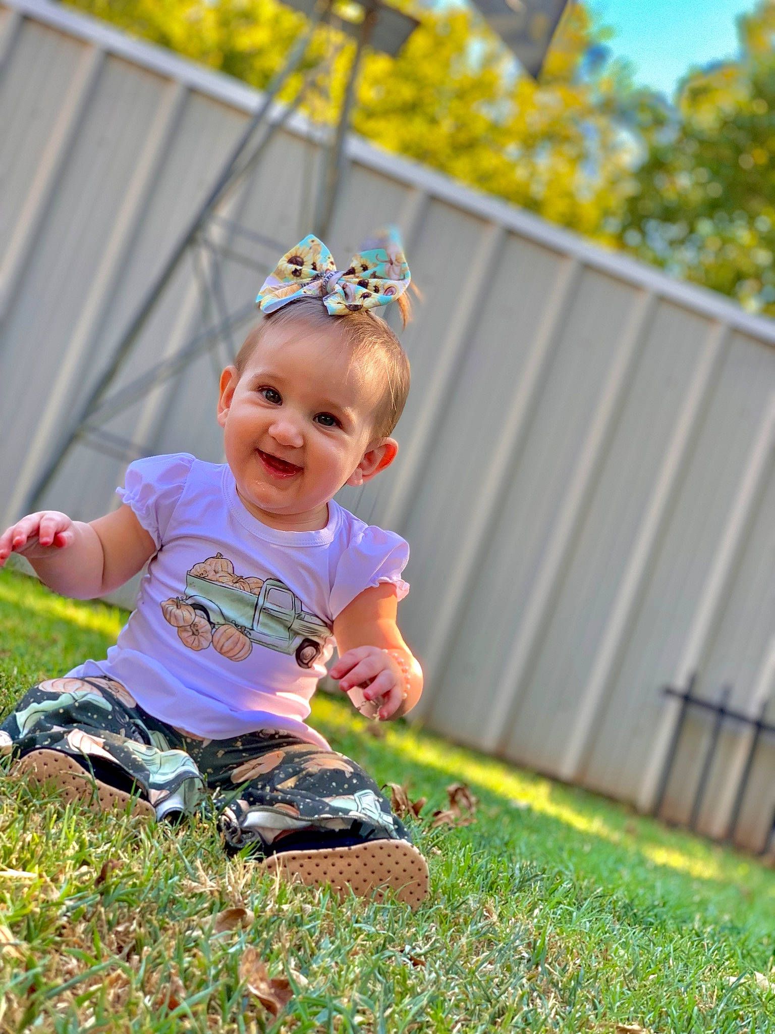 Blair joined the competition — help win amazing prizes! baby, baby_toddler_clothing, child, fence, grass, grassland, happy, hat, headband, headpiece, joy, lawn, leaf, pattern, people_in_nature, person, plant, recreation, smile, toddler