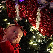 Freya joined the competition — help win amazing prizes! baby, infant, holiday, christmas, lights, decoration, red_clothing, bow, face, headband, toddler, festive, glowing, indoors, celebration, cute, smiling, cozy, sparkly, background