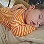 Taelynn is registered to the contest to win money with this photo: baby, sleeping, striped_clothing, orange, white, hand, comfort, soft_surface, peaceful, infant, resting, closeup, portrait, child, cute, relaxation, indoors, casual, cozy, toddler