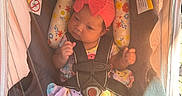 Nyla joined the competition — help win amazing prizes! baby, car_seat, infant, headband, colorful_clothing, safety_harness, seatbelt, indoors, child, cute, sunlight, pink, patterned_pillow, newborn, foot, hand, face, person, resting, seat