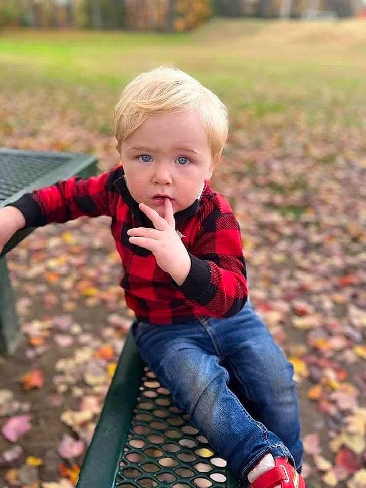 Jamison is registered to the contest to win money with this photo: arm, baby_toddler_clothing, eye, face, facial_expression, fun, grass, green, hairstyle, hand, happy, leaf, leisure, outerwear, people_in_nature, person, photograph, plant, red, toddler